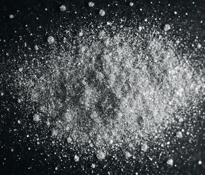 Polvo de aluminio en forma de partículas metálicas finas sobre fondo oscuro, altamente explosivo en contacto con el aire