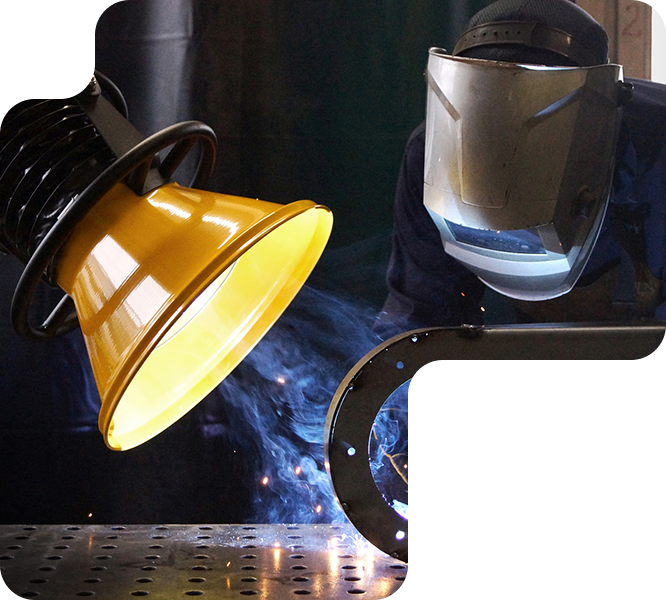 Operario soldando con campana de aspiración captando humos en el punto de emisión